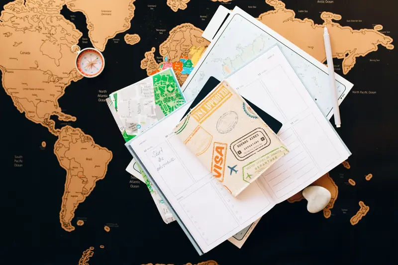 Reisepass, Kompass und Notizbuch auf einer Landkarte